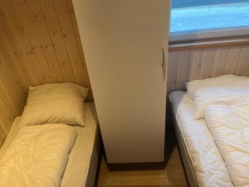 two beds in a small room with a window at Storebælt camping in Korsør