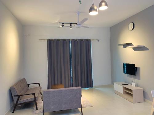 ein Wohnzimmer mit einem Stuhl und einem TV in der Unterkunft DENDEN HOMESTAY - SANDAKAN in Sandakan