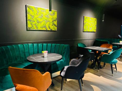 a restaurant with green booths and tables and chairs at HOTEL FINIX CASINO in Kulata