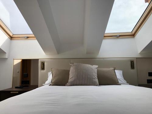 1 dormitorio con 1 cama blanca grande y ventanas en Quatrecantons Camprodon, en Camprodon