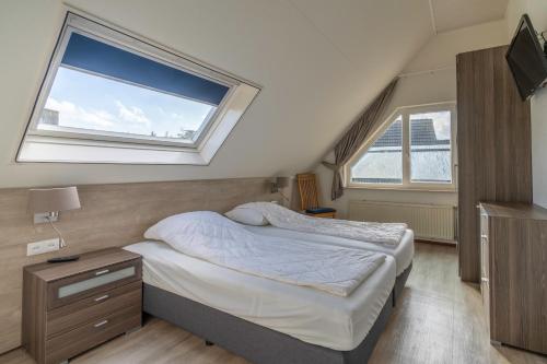 a small bedroom with a bed and a window at Villapark Kamperfoelie 49 in De Koog