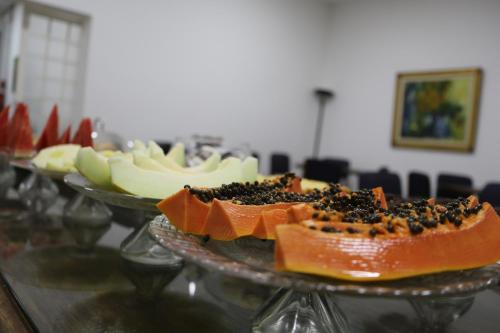 a plate of food on a table with fruit at Pousada Água Eterna - Próximo ao Museu de Cera, Hot Beach e Thermas dos Laranjais - By UP Hotel in Olímpia