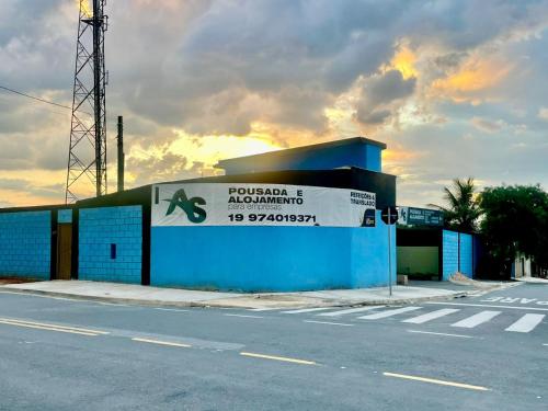 un edificio con un letrero al lado de una calle en Pousada Alojamento AS en Viracopos