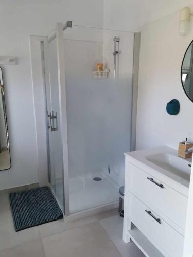 une salle de bain blanche avec une douche et un lavabo dans l'établissement Charmante maisonnée à la campagne, à La Garnache