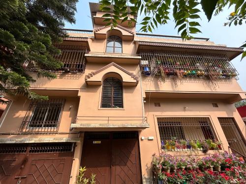 a house with flower boxes on the balcony at Mulaqat Homestay in Siliguri