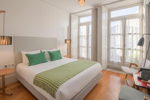 a bedroom with a large bed with green pillows at Fil's Place in Porto