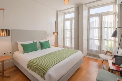 Un dormitorio con una cama grande con almohadas verdes. en Fil's Place, en Oporto
