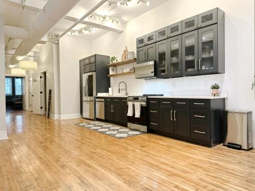 a large kitchen with black cabinets and a wooden floor at The Historic Lyric Presidential Suite in Cincinnati