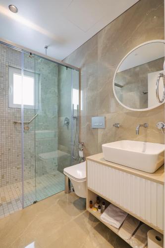 Un baño con inodoro, lavabo y ducha. en L'Amo del Mare Hotel, en Ksamil