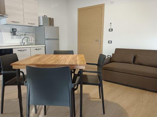a kitchen and living room with a wooden table and chairs at Residence Superstar in San Martino di Lupari
