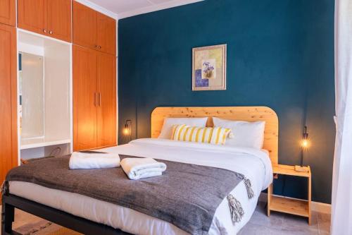 1 dormitorio con 1 cama grande y pared azul en Becca House Nakuru en Nakuru