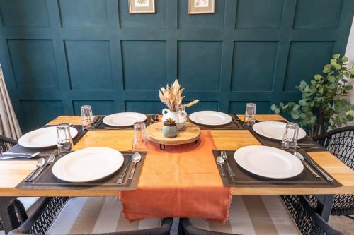 una mesa de madera con placas blancas. en Becca House Nakuru en Nakuru