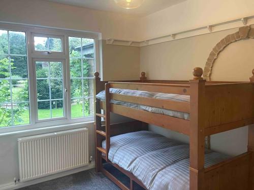 1 dormitorio con 2 literas y ventana en Edge view, outdoor adventure focused cottage, sleeps 8, en Bamford