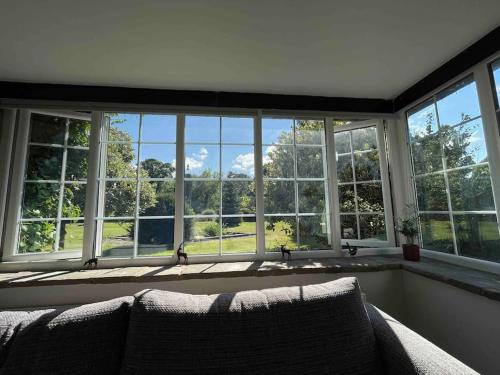 a living room with a large window with a couch at Edge view, outdoor adventure focused cottage, sleeps 8 in Bamford