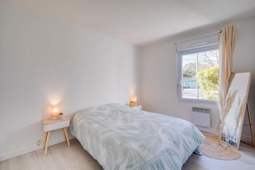 - une chambre blanche avec un lit et une fenêtre dans l'établissement Charmant Appartement avec Jardin, à Pessac