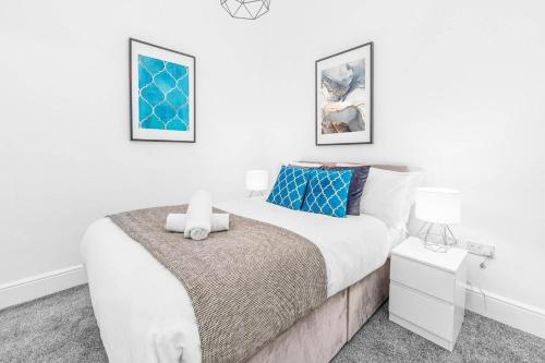 a bedroom with a large bed and two pictures on the wall at Wolverhampton Luxury Apartment - Free Wifi & Netflix - On Street Parking 12C in Birmingham