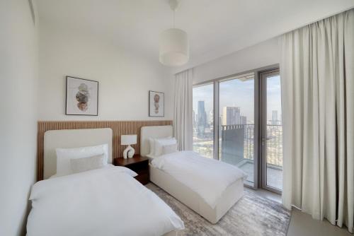a hotel room with two beds and a large window at Luxury Apartment in Dubai in Dubai