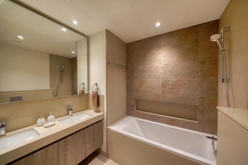 a bathroom with two sinks and a tub and a shower at Luxury Apartment in Dubai in Dubai