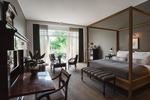 um quarto com uma cama de dossel, uma mesa e cadeiras em Nimb Hotel em Copenhague