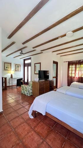 a bedroom with two beds and a flat screen tv at Hotel San Marco  in Santo Domingo