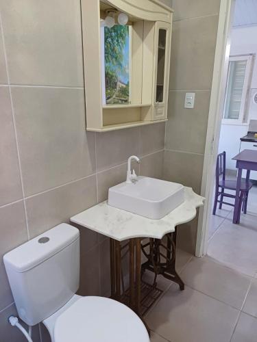 a bathroom with a white toilet and a sink at Casa do Mato II in São Lourenço do Sul
