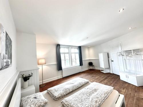 biały pokój z 2 łóżkami i oknem w obiekcie Business Apartments Niederbipp ZIMMERzuVERMIETEN w mieście Niederbipp