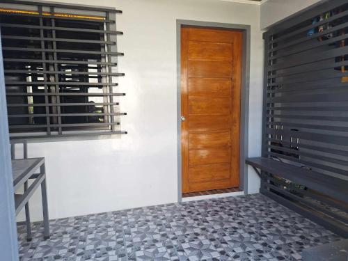 einen Flur mit einer Holztür und einer Bank in der Unterkunft Travellers&Backpackers Apartment in Calapan