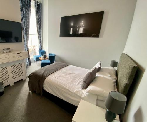 a bedroom with a bed and a tv on the wall at East Beach Hotel in Eastbourne
