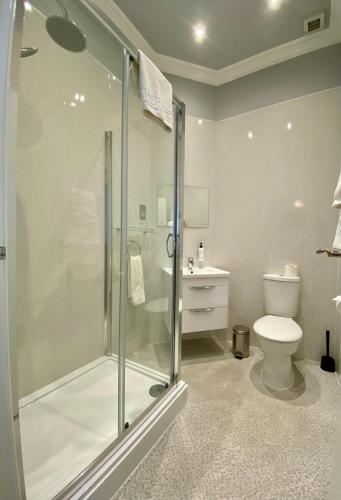 a bathroom with a shower and a toilet at East Beach Hotel in Eastbourne