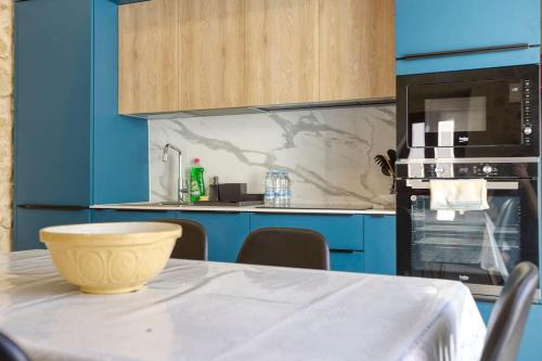 a blue kitchen with a table with a bowl on it at A 2BR farmhouse with private pool in Zebbug & BBQ by 360 Estates in Żebbuġ