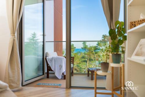 una stanza con una porta scorrevole in vetro che dà su un balcone di Apartament Lux Sea z dostępem do basenu,saun-Pinea Apartments Pobierowo-SANNEL Apartments for rent a Pobierowo
