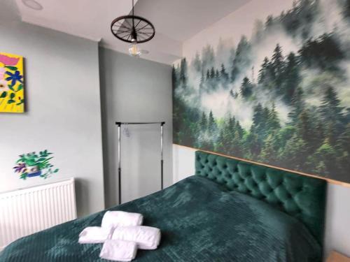 トビリシにあるBlueVibe Apartmentのベッドルーム1室(緑色のベッド1台、タオル2枚付)