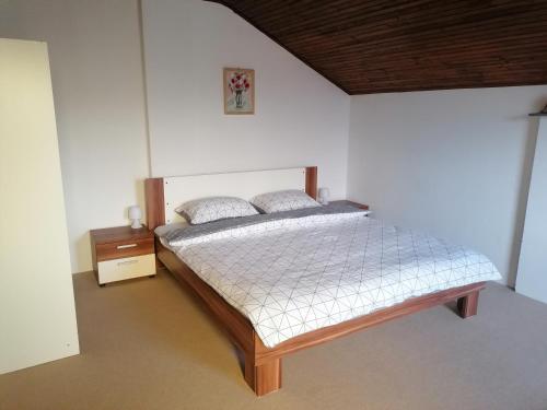 a bedroom with a bed and a night stand at Kuća za odmor Ke ti je in Velika Gorica