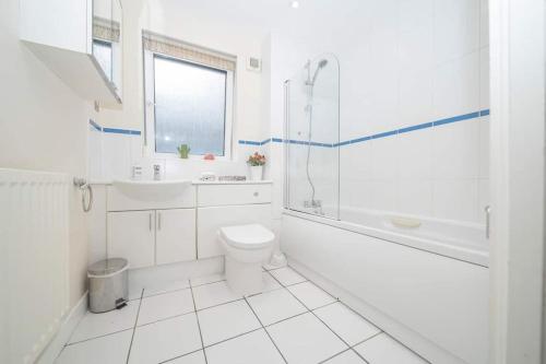 een witte badkamer met een toilet en een wastafel bij BIG GATEAWAY HENDO PARTY HOUSE NEAR STATION in Brighton & Hove