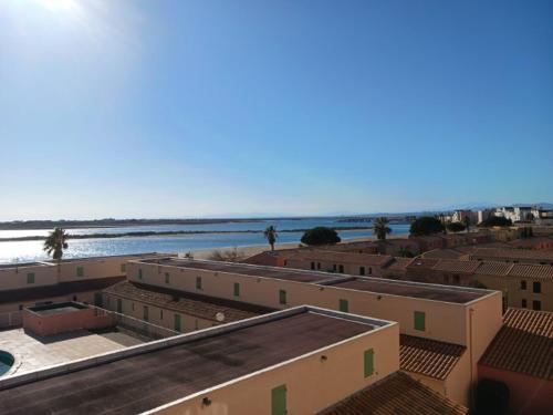un groupe de bâtiments avec l'océan en arrière-plan dans l'établissement Appartement avec magnifique vue sur mer, à Gruissan