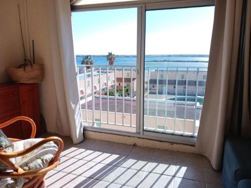 Cette chambre dispose d'une grande fenêtre offrant une vue sur l'océan. dans l'établissement Appartement avec magnifique vue sur mer, à Gruissan