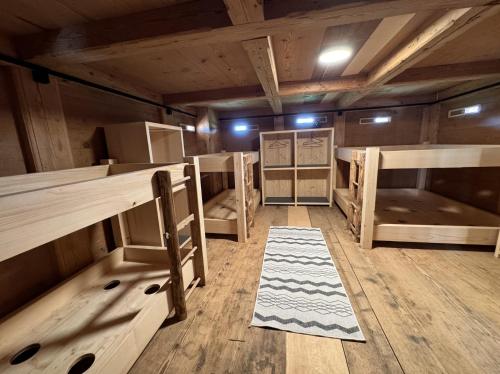 a room with bunk beds and a rug on the floor at Ferienhaus Spycher im Emmental in Lützelflüh