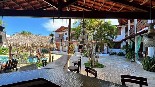 a patio with a table and chairs and a pool at Hotel Pousada 360 in Paracuru