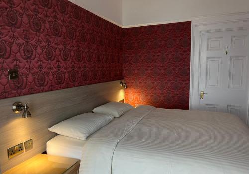 a bedroom with a white bed with red walls at Eden Vale First Floor Sea View Apartment in Morecambe