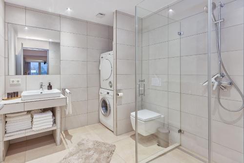 bagno con doccia, lavandino e lavatrice di Penthouse Palais Mosel a Traben-Trarbach