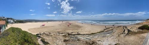 a group of people on a beach near the ocean at La Vista Lodge in Plettenberg Bay