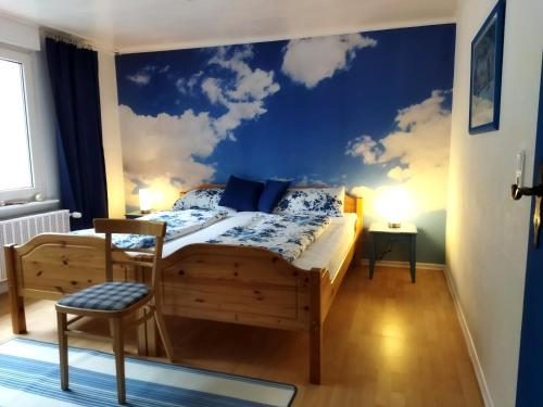 ボッパルトにあるFerienhaus Loreleytalのベッドルーム1室(壁に雲が描かれたベッド1台付)