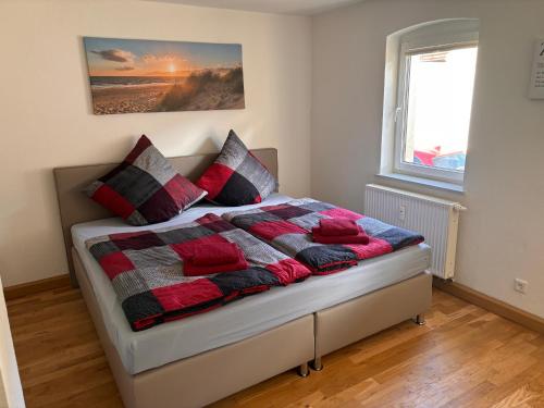 sypialnia z łóżkiem z czerwonymi i czarnymi poduszkami w obiekcie Ferienwohnung Freital-City w mieście Freital