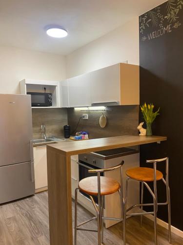 a kitchen with a counter and two stools in it at Harmony Apartman BB in Banská Bystrica