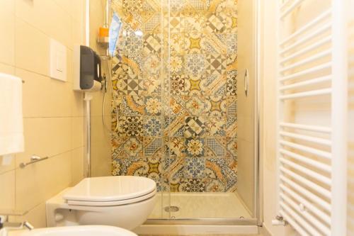a bathroom with a toilet and a tiled shower at Tenuta Amostuni-Country House in Ostuni