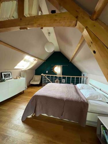 une chambre avec un grand lit dans un grenier dans l'établissement Villa dans son écrin de verdure, piscine privée, totalement privée, à Missy-sur-Aisne