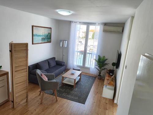 ein Wohnzimmer mit einem blauen Sofa und einem Tisch in der Unterkunft APARTMENT MARINA VIEW in Zadar