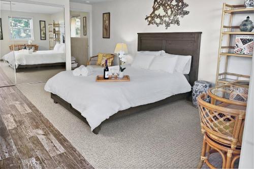 a bedroom with a large white bed with a table at Secret Stairs Studio #1 in Los Angeles