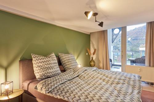 a bedroom with a bed with a green wall at Penthouse Palais Mosel in Traben-Trarbach