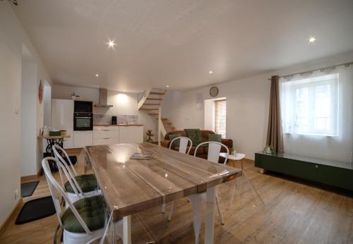 een keuken en een woonkamer met een tafel en stoelen bij La Nuit Des Héros in Sainte-Mère-Église